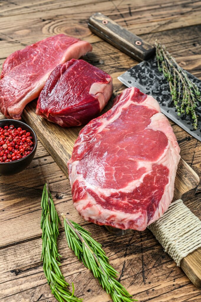 raw black angus beef meat steaks fillet Mignon, rib eye or cowboy, Striploin or new york