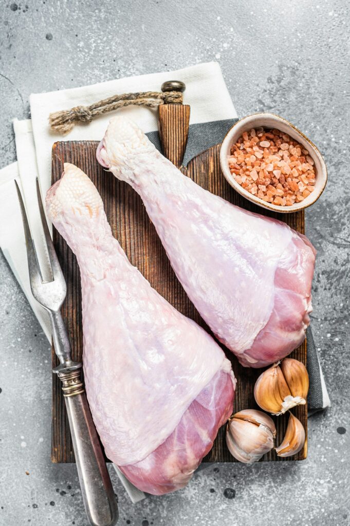 Raw turkey legs, Poultry meat. Gray background. Top view