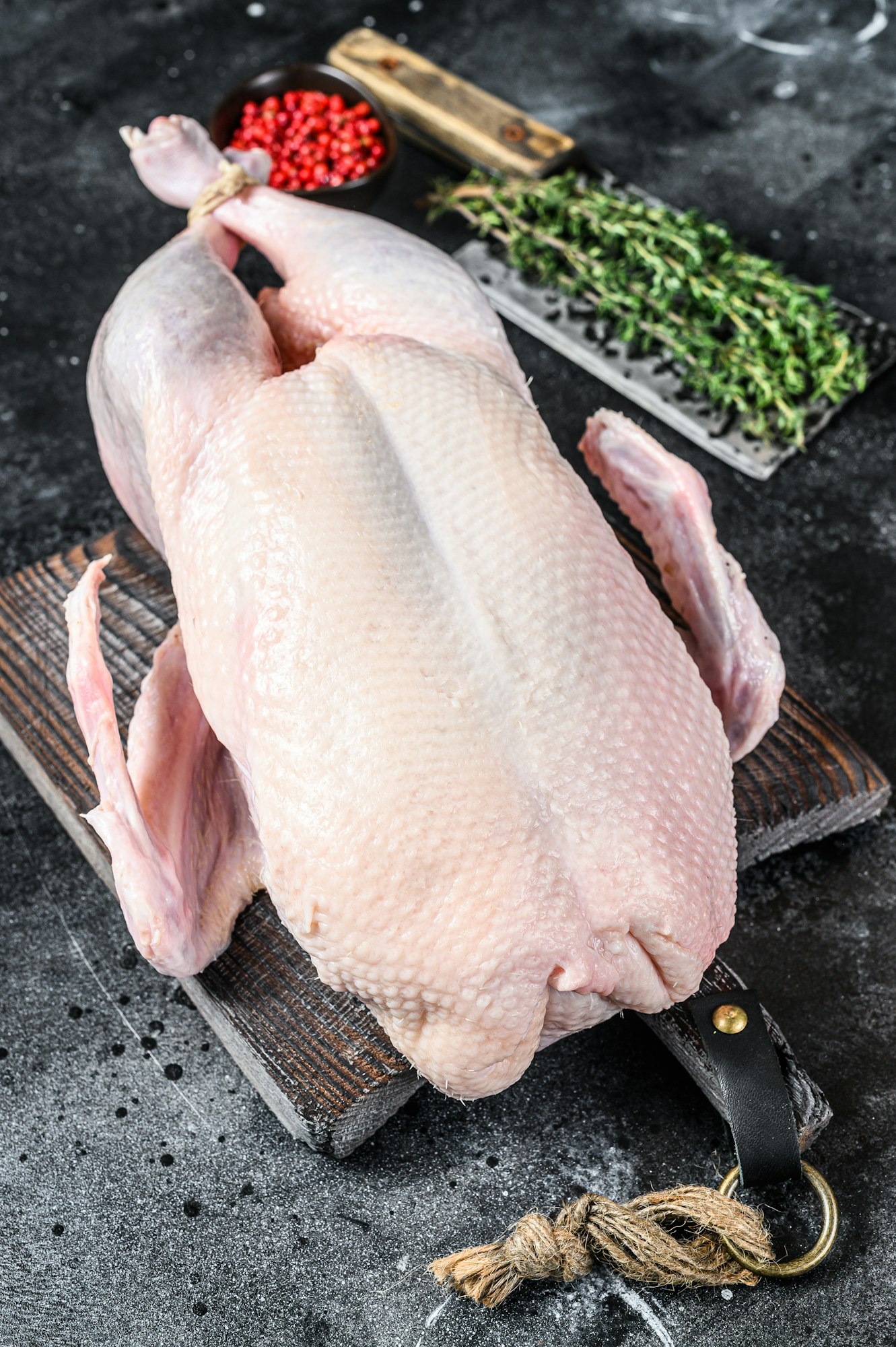 Raw whole duck, poultry meat. Black background. Top view