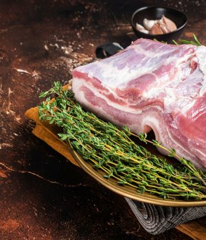 Farm fresh Pork belly, raw meat in a plate with spices. Dark background. Top view. Copy space